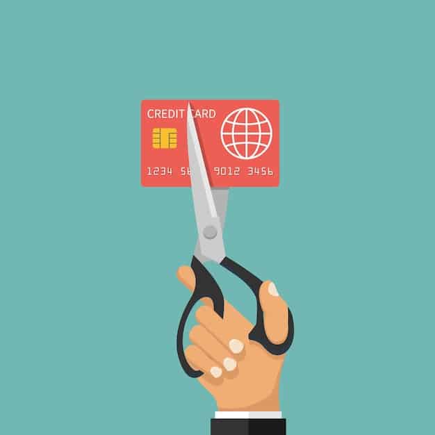 A hand hovering over a pair of scissors about to cut a credit card, symbolizing the act of closing an old credit card account. Focus on the potential negative consequences of this action.