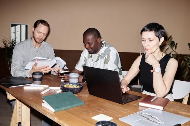 A group of diverse small business owners discussing strategies and opportunities around a conference table, with laptops and documents spread out in front of them.