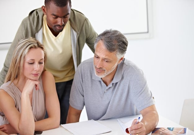 A close-up photo of a FEMA representative assisting a family at a disaster recovery center, reviewing paperwork and explaining the application process.