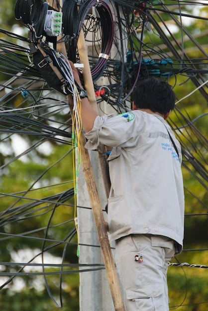 Workers installing fiber optic cables underground, highlighting the expansion of broadband internet access in rural areas.