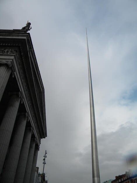A close-up of the Supreme Court building in Washington, D.C., with a gavel resting on the scales of justice in the foreground. The sky is overcast, creating a somber mood.