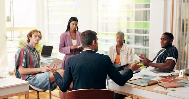 A diverse group of office workers engaged in a collaborative brainstorming session around a conference table. The atmosphere is bright and energetic, with laptops and notebooks scattered around, symbolizing productivity and teamwork.