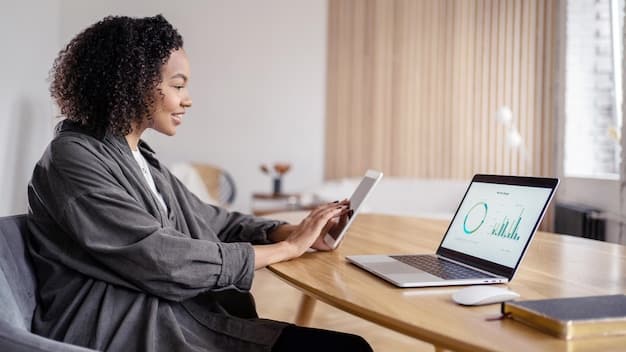 A person sitting at a desk using a laptop, looking at financial charts and graphs, with an expression of careful analysis.