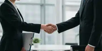 Professionals networking, shaking hands in a modern office, representing successful job search